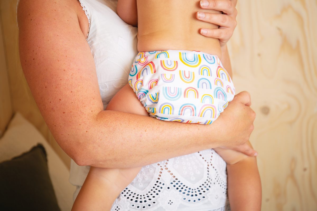 mum-holding-baby-wearing-dream-time-nappy-totsbots