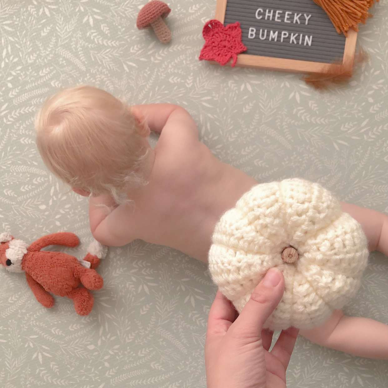 get-crafty-this-halloween-blog-baby-lying-on-front-knitted-pumpkin-on-top